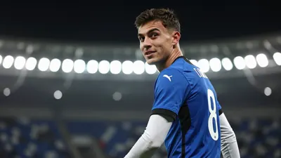 A photorealistic image of a 22-year-old midfielder in a blue and black jersey with white sleeves, playing with the number...