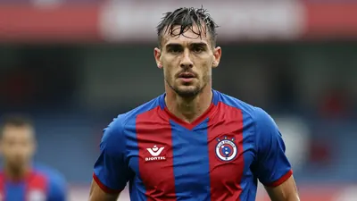 Mid-30s muscular Club Brugge midfielder, waist-up, intense gaze, short dark hair, light stubble, wearing the blue-red...