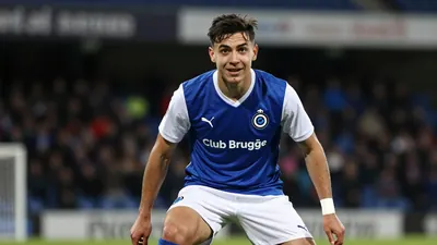 A photorealistic image of an anonymous 21-year-old defender of Club Brugge, wearing a blue jersey with a white collar and...