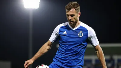A tight action crop of an anonymous Club Brugge defender, 25-30 years old, wearing a blue jersey with white sleeves and a...