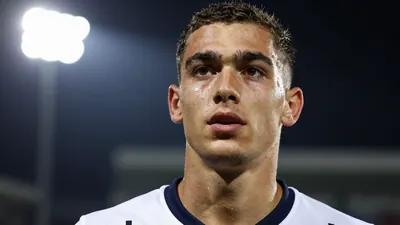 A tight action crop of a 22-year-old midfielder in a Westerlo jersey, and photorealistic skin and fabric texture, with...